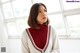 A woman in a red turtle neck sweater sitting at a table.