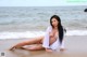 A woman sitting on a beach next to the ocean.