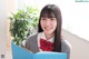 A young woman in a school uniform holding a book.