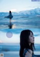 A woman in a blue dress standing in the water.