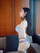 A woman in lingerie posing on a couch.
