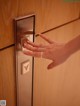 A woman's hand is pressing a button on a door.