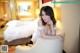 A woman sitting on a chair in a hotel room.