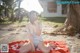 A woman in a bathing suit sitting on a beach towel.