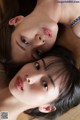 A couple of young women laying on top of each other.