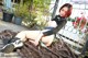 A woman sitting on top of a wooden deck next to a fence.